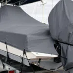 Outboard motor cover on a trailered boat with a fitted main cover