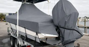 Outboard motor cover on a trailered boat with a fitted main cover
